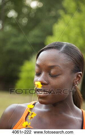 Young woman smelling a flower View Large Photo Image Stock Image - Young woman smelling a flower. Fotosearch