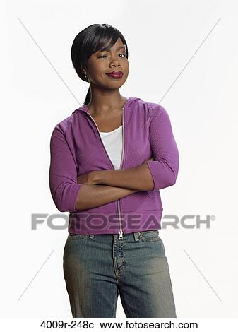 Stock Image - Young woman standing with her arms crossed. Fotosearch