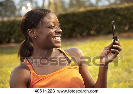 Young woman taking a picture of herself with a mobile phone View Large Photo Image Stock Image - Young woman taking a picture of herself with a mobile phone. Fotosearch