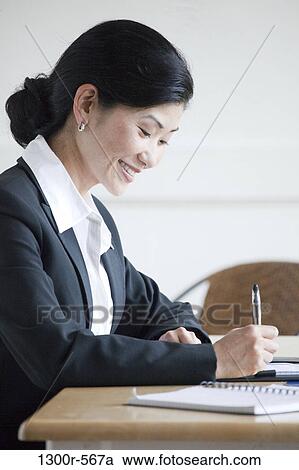 Businesswoman working at a desk View Large Photo Image Stock Image - Businesswoman working at a desk. Fotosearch