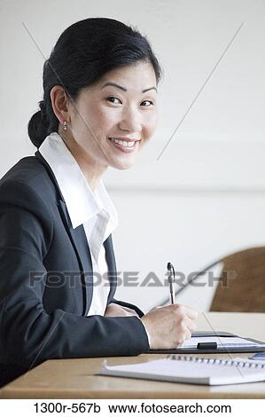 Businesswoman working at a desk View Large Photo Image Stock Image - Businesswoman working at a desk. Fotosearch