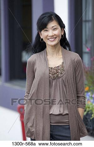 Mid adult woman walking in a street View Large Photo Image Stock Image - Mid adult woman walking in a street. Fotosearch