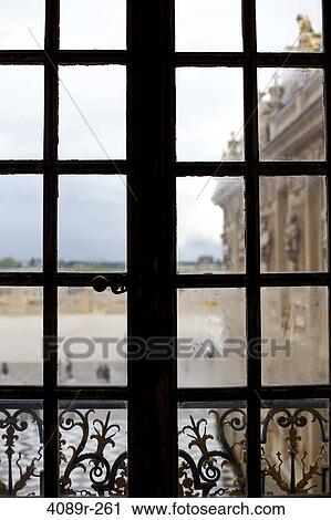 Stock Image - Tourists viewed through the window of a palace, Chateau De Versailles, Versailles, Paris, Ile-De-France, France. Fotosearch