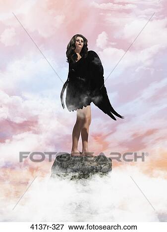 Angel standing on a rock in the clouds View Large Photo Image Stock Photo - Angel standing on a rock in the clouds. Fotosearch