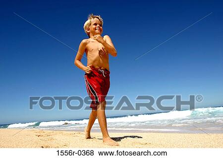 Boy strutting down beach View Large Photo Image Stock Photo - Boy strutting down beach. Fotosearch