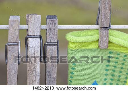 Stock Image - Close up of wooden clothespins on clothes line. Fotosearch