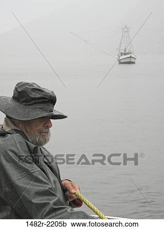 Stock Image - Fisherman in a boat, Warm Springs Bay, Baranof Island, Alaska, USA. Fotosearch