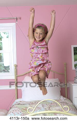 Girl jumping on the bed View Large Photo Image Stock Image - Girl jumping on the bed. Fotosearch