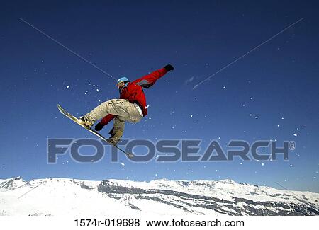 Stock Photo - Low angle view of a man snowboarding. Fotosearch