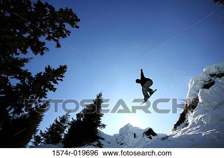 Stock Photograph - Low angle view of a person snowboarding. Fotosearch