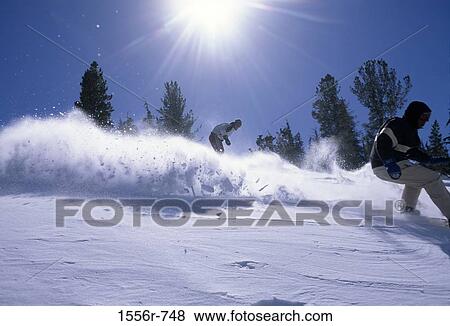 Low angle view of two people snowboarding View Large Photo Image Stock Photo - Low angle view of two people snowboarding. Fotosearch
