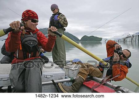 Man taking a picture of a young woman rafting in a lake, Alsek Lake, Alaska, USA View Large Photo Image Picture - Man taking a picture of a young woman rafting in a lake, Alsek Lake, Alaska, USA. Fotosearch