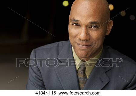 Stock Photography - Portrait of young smiling businessman outdoors at night. Fotosearch