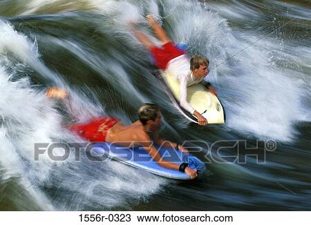 Stock Image - Two teenage boys boogie boarding. Fotosearch