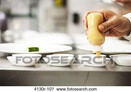 USA, New York City, Brooklyn, close up of chef's hand applying sauce with squeeze bottle View Large Photo Image Stock Photo - USA, New York City, Brooklyn, close up of chef's hand applying sauce with squeeze bottle. Fotosearch