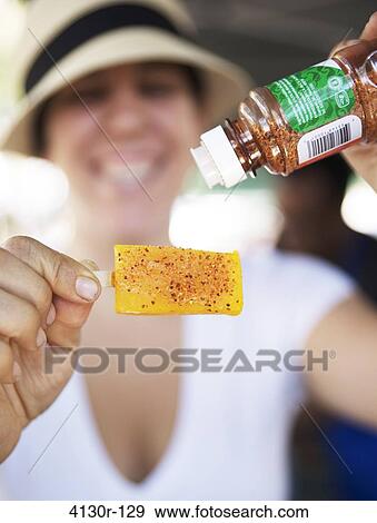 USA, New York State, New York City, Hester Street Market, La NewYorkina, Woman holding mango ice lolly with chili powder View Large Photo Image Stock Photo - USA, New York State, New York City, Hester Street Market, La NewYorkina, Woman holding mango ice lolly with chili powder. Fotosearch