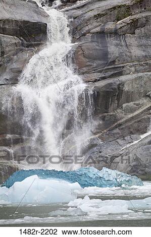 Stock Image - Waterfall and blue icebergs, Endicott Arm, Alaska, USA. Fotosearch