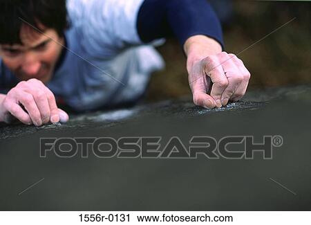 Stock Image - Young adult man mountain climbing, Peak District, England. Fotosearch