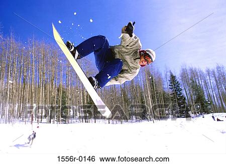 Young adult man performing stunt on snowboard View Large Photo Image Stock Photograph - Young adult man performing stunt on snowboard. Fotosearch