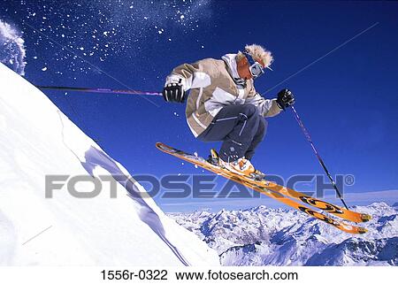 Stock Image - Young adult man skiing downhill. Fotosearch