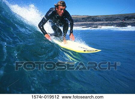 Stock Image - Young adult man surfing, Lanzarote, Canary Islands. Fotosearch