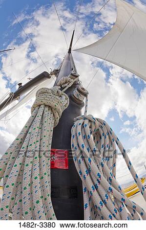 Stock Image - Upward view of sailboat Mast and sail. Fotosearch