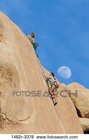USA, California, Joshua Tree National Park, Upward view of climbing woman View Large Photo Image Stock Photo - USA, California, Joshua Tree National Park, Upward view of climbing woman. Fotosearch