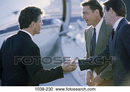 Stock Image - meeting, airplane, business, outdoors, individuals, business travel, handshakes. Fotosearch