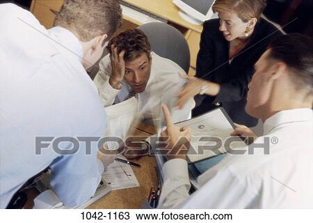 Stock Image - meeting, desk, overwhelmed, business, chaotic, frustrated. Fotosearch
