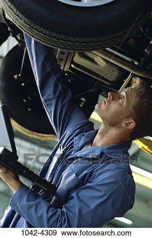 Stock Photo - people, car, outdoors, blond, overalls, repair. Fotosearch
