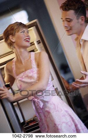 Stock Photo - people, couple, refrigerator, gesturing, pleading, kitchen, irritated. Fotosearch