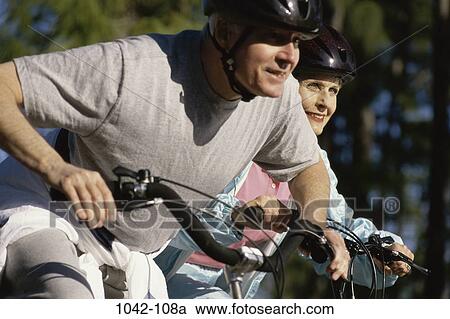 Stock Image - people, couple, senior, bicycle, outdoors, sports. Fotosearch