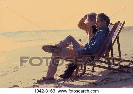 people, couple, sitting, beach, Middle-aged, chairs, sunny View Large Photo Image Stock Image - people, couple, sitting, beach, Middle-aged, chairs, sunny. Fotosearch