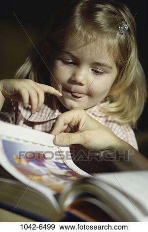 Stock Photo - people, listening, reading, book, girl, tongue, child. Fotosearch