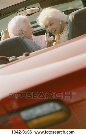 Stock Photograph - people, lost, couple, map, senior, car, convertible. Fotosearch