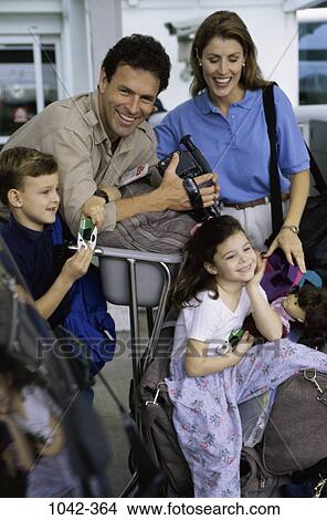 Picture - people, luggage, outdoors, camera, family, vacation, cart. Fotosearch