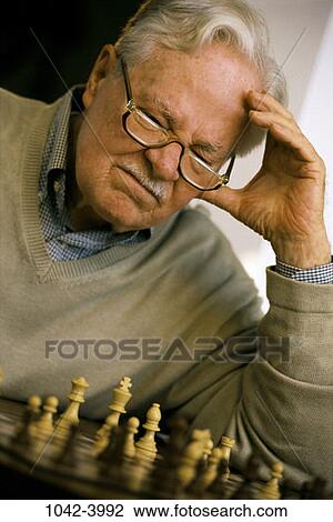 Stock Image - people, playing, chess, eyeglasses, senior, concentrating. Fotosearch
