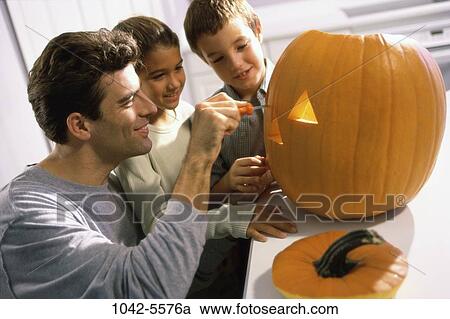 people, pumpkin, tradition, Halloween, family, anticipation, father View Large Photo Image Stock Image - people, pumpkin, tradition, Halloween, family, anticipation, father. Fotosearch