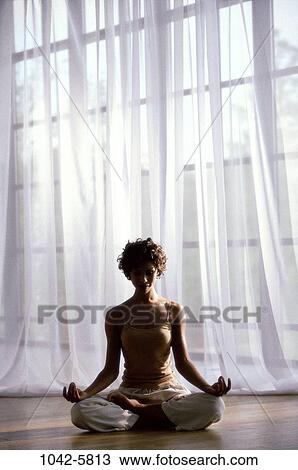 Stock Image - people, relaxation, woman, meditation, window, sitting, floor. Fotosearch