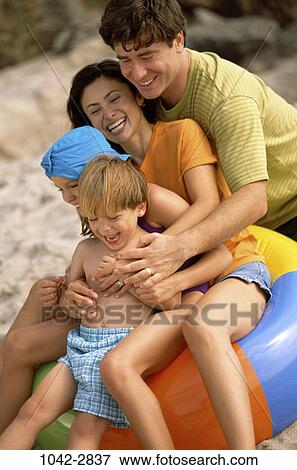 people, smiling, beach, laughing, inner tube, commitment, family View Large Photo Image Stock Photo - people, smiling, beach, laughing, inner tube, commitment, family. Fotosearch