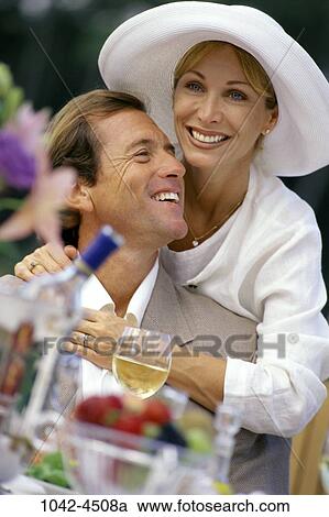 Stock Image - people, smiling, hat, couple, wine, laughing, outdoors. Fotosearch