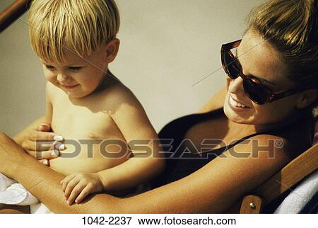 people, smiling, sitting, mother, beach, sunglasses View Large Photo Image Stock Photo - people, smiling, sitting, mother, beach, sunglasses. Fotosearch