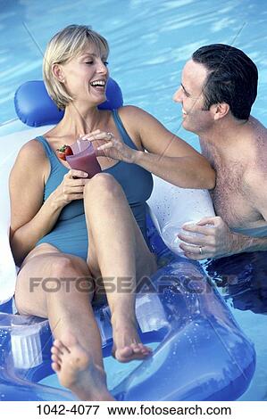 Stock Photo - people, swim, floating, pool, couple, swimming, drinking. Fotosearch
