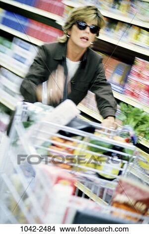 Picture - people, woman, earring, sunglasses, shopping, jacket, aisle. Fotosearch