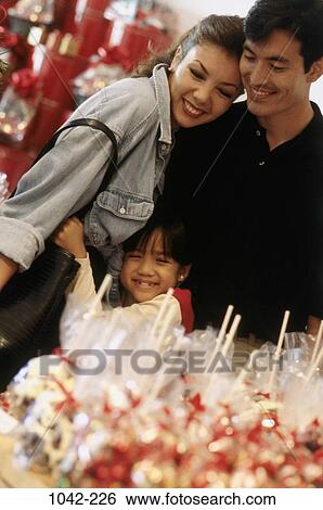 Stock Photograph - shopping, candy, hugging, festive, Christmas, family, Asian. Fotosearch