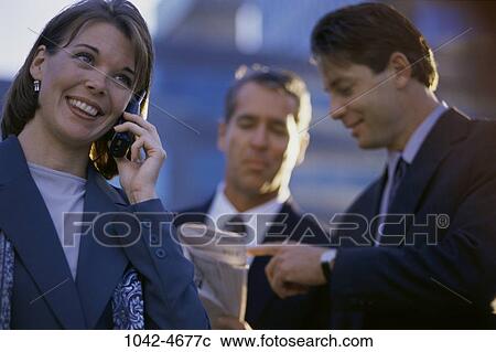 Stock Image - telephone, phone, business, outdoors, cell phone, cell, Businesspeople outdoors phone. Fotosearch