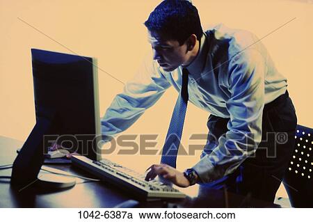 Stock Image - tie, desk, busy, computer, typing, Middle-aged. Fotosearch