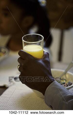 Stock Image - hand, glass, orange, orange juice, breakfast, bowl, holding. Fotosearch
