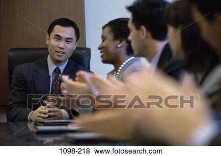 Stock Photo - meeting, group, multiethnic, blur, clapping, pleased. Fotosearch