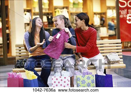 Stock Image - multiethnic, people, bench, sitting, shopping, friends, stores. Fotosearch